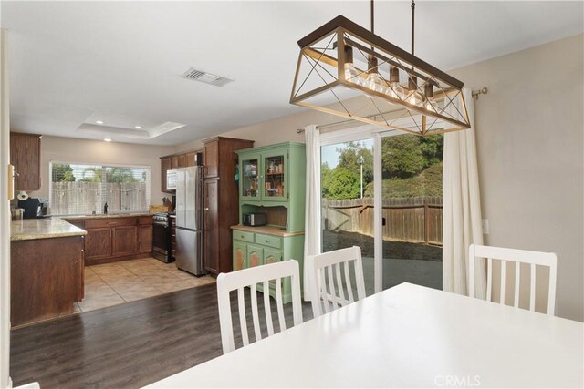 dining space with a raised ceiling and light hardwood / wood-style floors