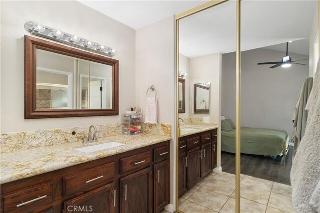 bathroom with tile patterned flooring, vanity, and ceiling fan