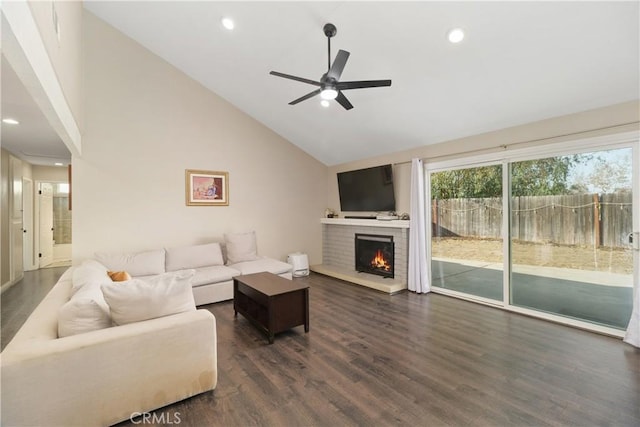 living room featuring ceiling fan, dark hardwood / wood-style floors, high vaulted ceiling, and a brick fireplace