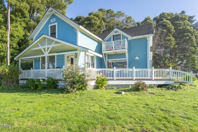 back of house featuring a porch, a yard, and a balcony