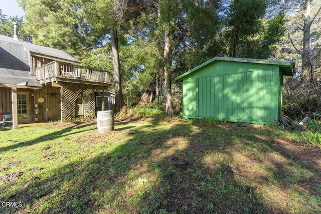 view of yard with a storage shed, an outbuilding, and a wooden deck