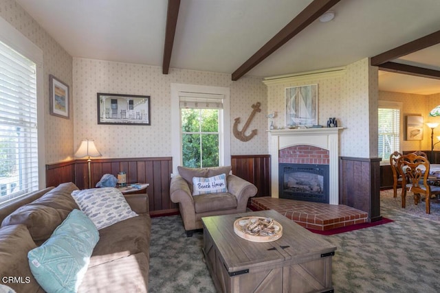 living room with vaulted ceiling with beams, carpet flooring, wallpapered walls, and a wainscoted wall