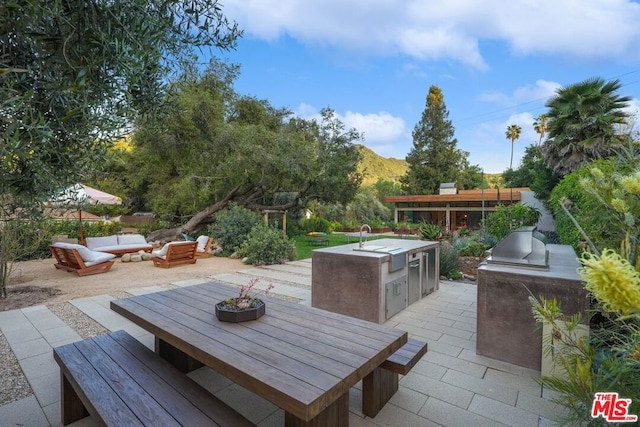 view of patio / terrace featuring area for grilling, a mountain view, an outdoor living space, and a grill