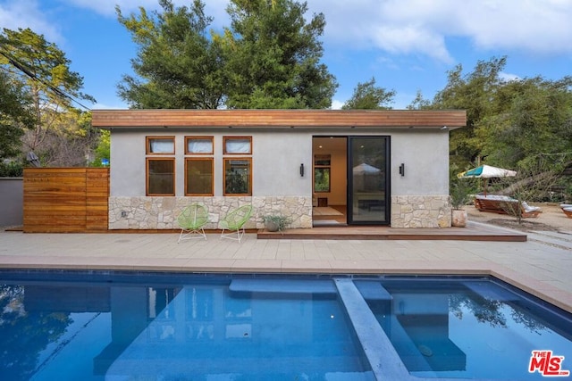 view of pool featuring an outdoor structure and a patio area