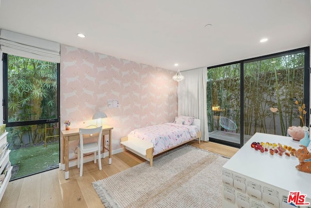 bedroom featuring floor to ceiling windows, access to exterior, and light hardwood / wood-style floors