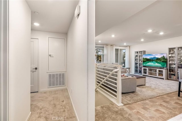 hall with light colored carpet