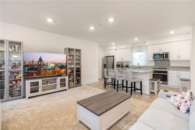 carpeted living room with sink