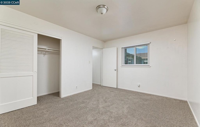 unfurnished bedroom featuring light carpet and a closet