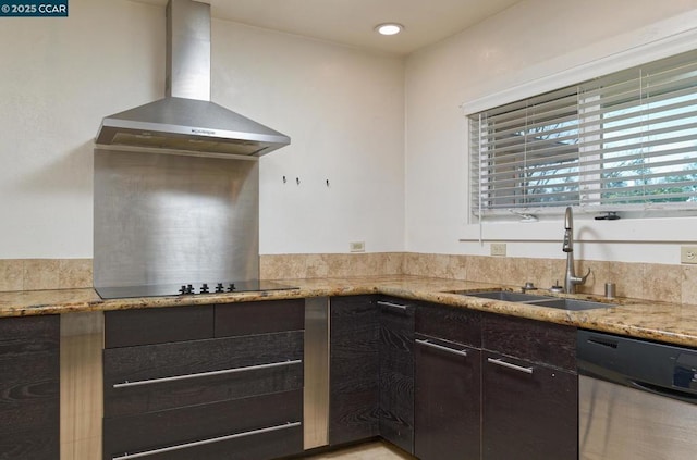 kitchen featuring light stone countertops, sink, wall chimney range hood, and stainless steel dishwasher