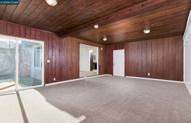 carpeted spare room featuring beam ceiling and wooden ceiling