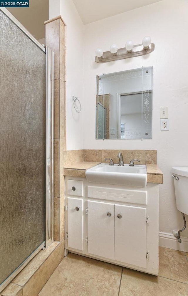 bathroom with tile patterned floors, an enclosed shower, vanity, and toilet