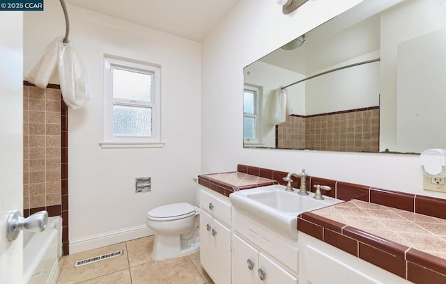 full bathroom with toilet, tile patterned flooring, vanity, and shower / bath combo with shower curtain