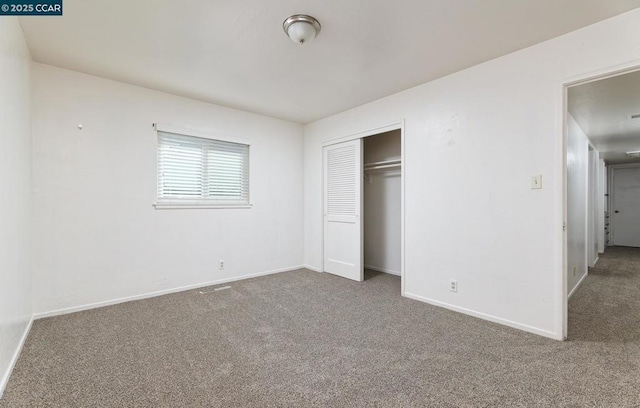 unfurnished bedroom with a closet and carpet flooring