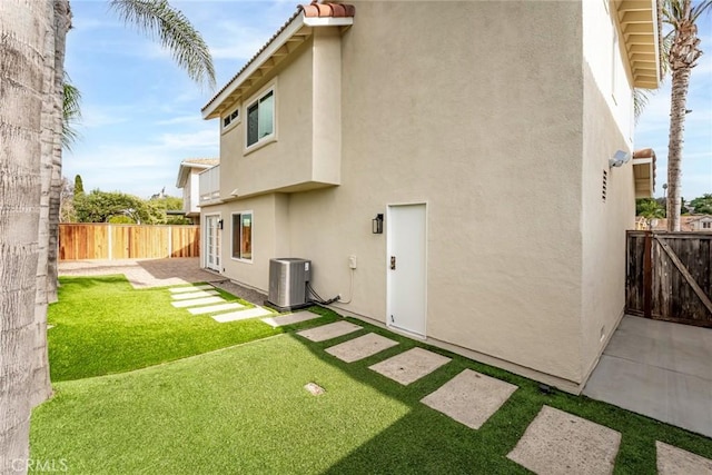 back of property with central air condition unit and a patio area