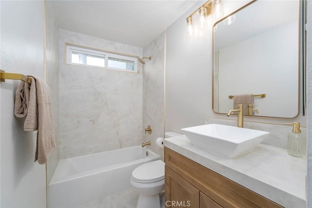 full bathroom featuring vanity, tiled shower / bath, and toilet