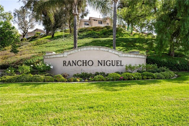 community / neighborhood sign featuring a yard