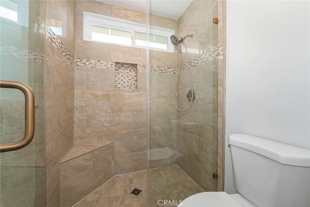 bathroom with toilet and an enclosed shower