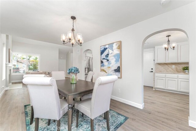 dining space featuring an inviting chandelier and light hardwood / wood-style flooring