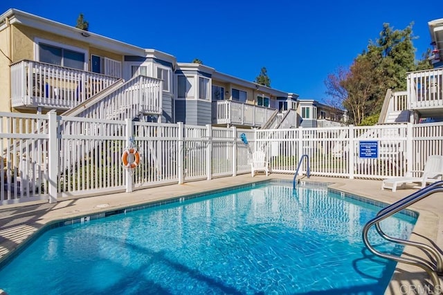 community pool with a residential view and fence