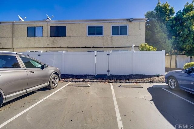 uncovered parking lot featuring fence