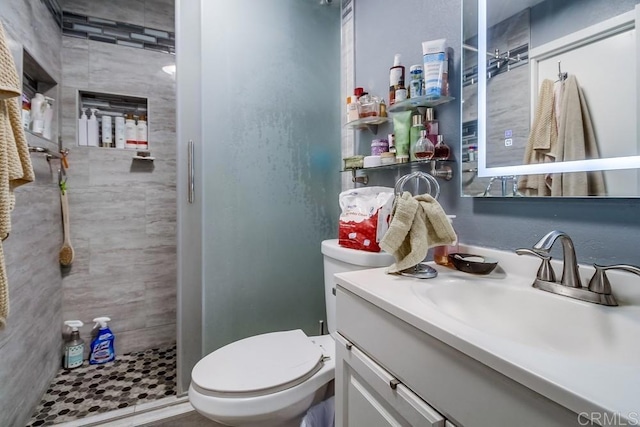 full bathroom featuring toilet, a stall shower, and vanity