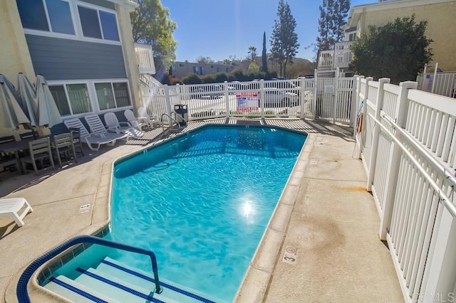 community pool featuring a patio area and fence