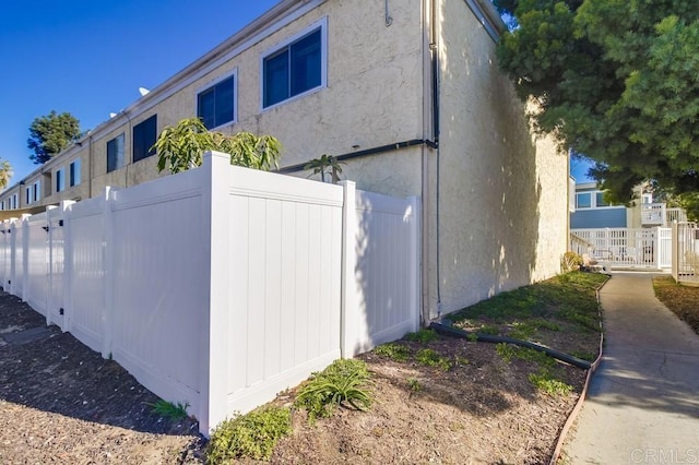 view of property exterior featuring fence and stucco siding