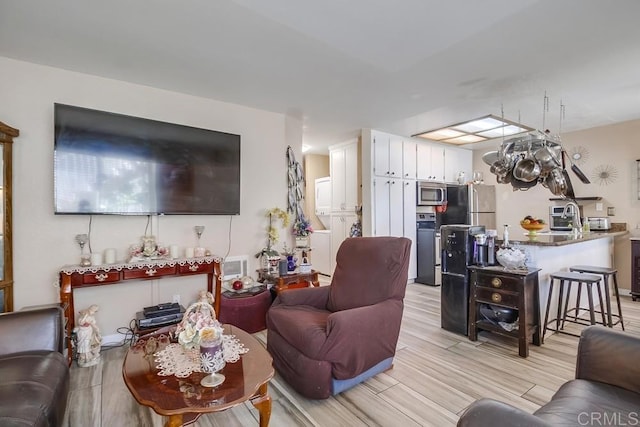 living room with light wood-style floors, a toaster, and visible vents