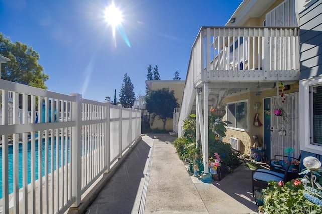 view of side of home featuring a patio area, a fenced backyard, and an outdoor pool