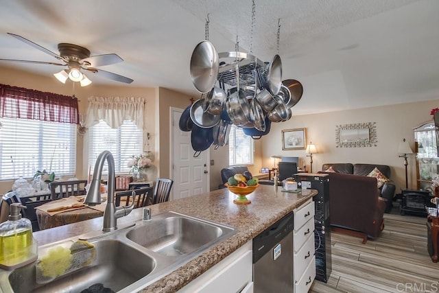 kitchen with a wealth of natural light, a sink, white cabinets, dishwasher, and ceiling fan