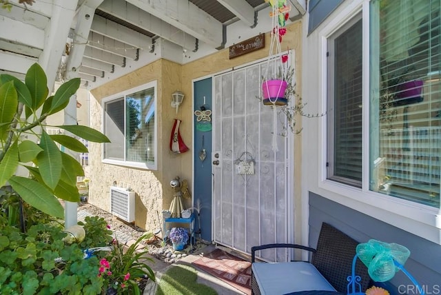 doorway to property featuring stucco siding