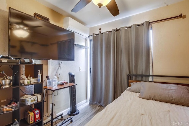 bedroom with wood finished floors and a wall mounted AC