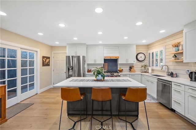 kitchen featuring appliances with stainless steel finishes, sink, white cabinetry, and a kitchen island