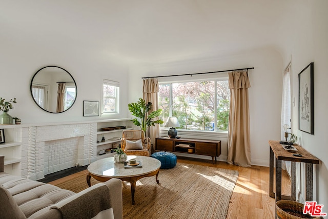 sitting room with built in shelves and light hardwood / wood-style flooring