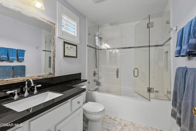 full bathroom featuring vanity, bath / shower combo with glass door, and toilet