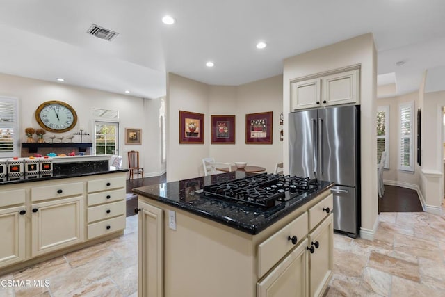 kitchen featuring black gas cooktop, cream cabinets, a kitchen island, high end refrigerator, and dark stone counters