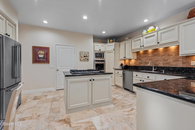 kitchen featuring sink, white cabinets, backsplash, dark stone counters, and stainless steel appliances