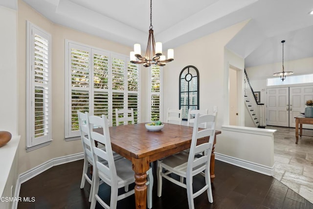 dining area with a tray ceiling, dark hardwood / wood-style floors, and a chandelier