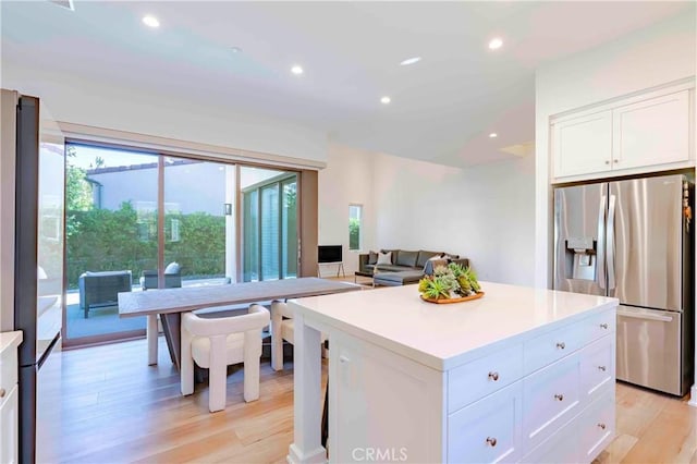 kitchen with white cabinetry, light hardwood / wood-style floors, stainless steel fridge, stainless steel refrigerator with ice dispenser, and a kitchen island