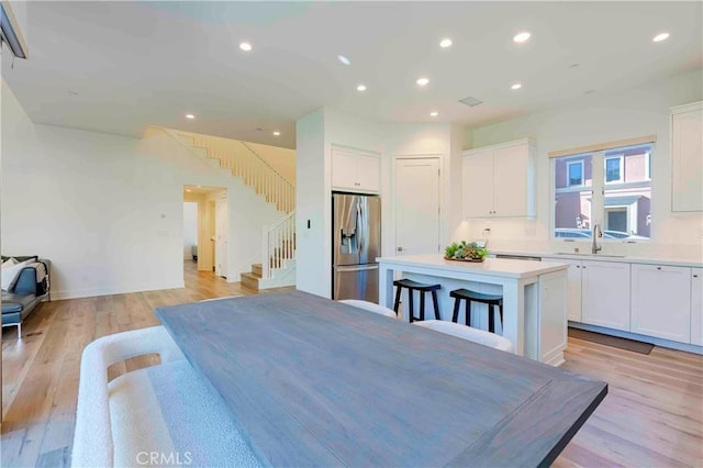 dining space with light wood-type flooring and sink