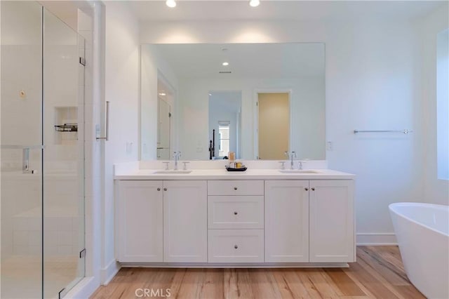 bathroom with vanity, independent shower and bath, and hardwood / wood-style flooring