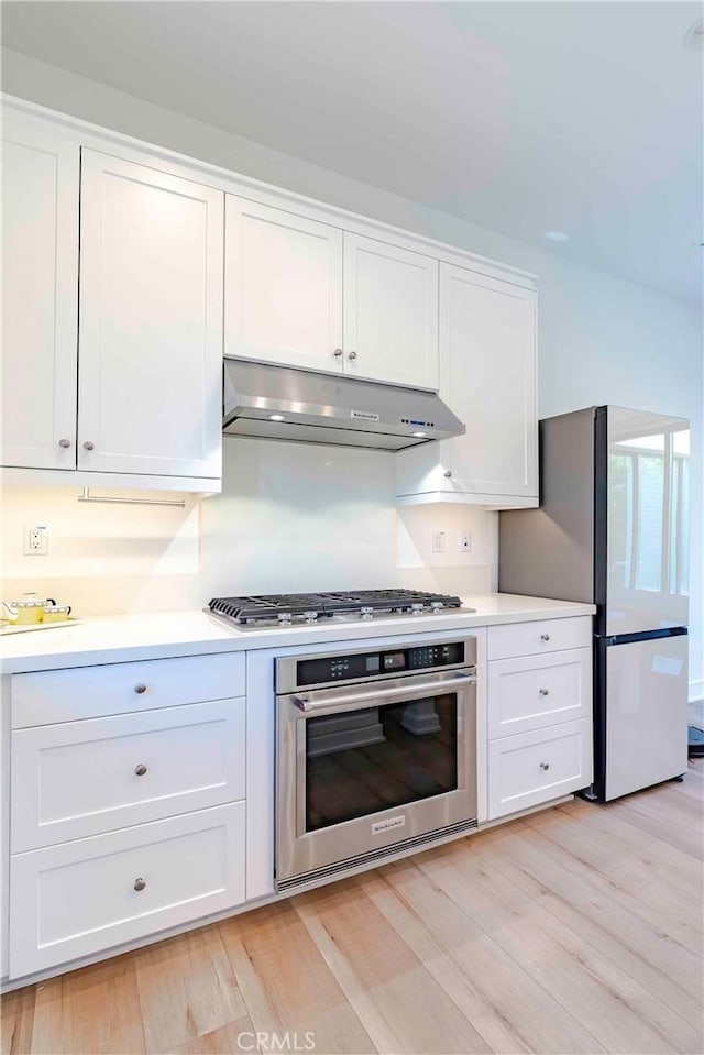 kitchen featuring light hardwood / wood-style floors, stainless steel appliances, and white cabinetry