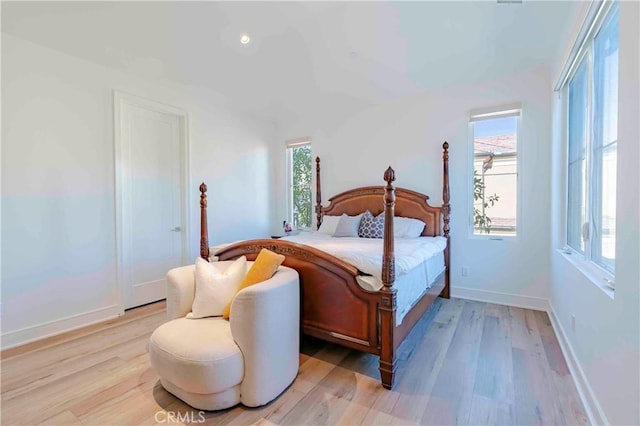 bedroom featuring light hardwood / wood-style floors and multiple windows