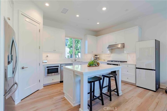 kitchen featuring white cabinets, stainless steel appliances, and a kitchen island