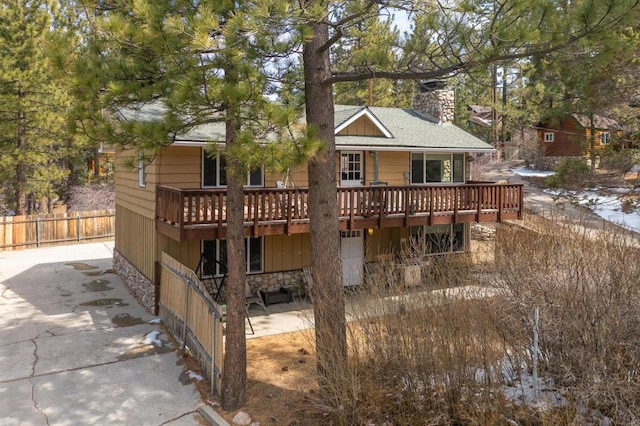 back of property featuring a deck and a patio