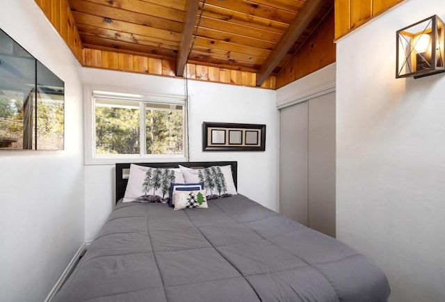 bedroom with a closet, wood ceiling, and vaulted ceiling with beams