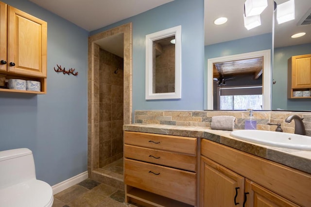 bathroom featuring toilet, walk in shower, and vanity