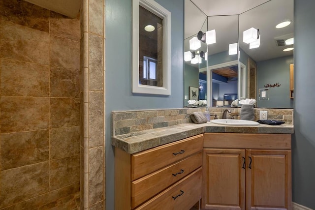 bathroom with walk in shower and vanity