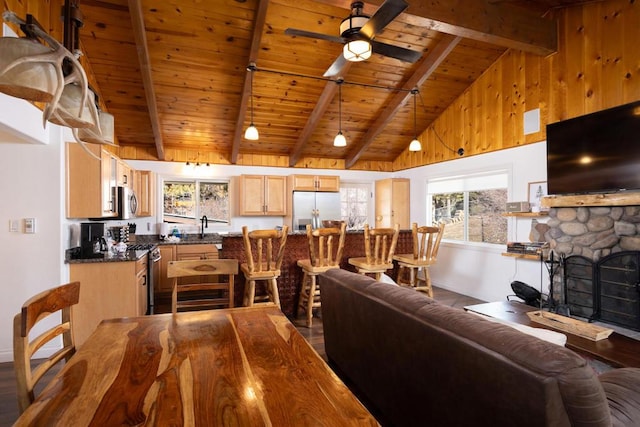 living room with ceiling fan, beamed ceiling, hardwood / wood-style flooring, high vaulted ceiling, and wooden ceiling