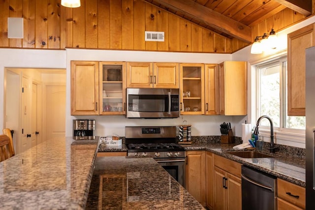 kitchen featuring dark stone countertops, lofted ceiling with beams, sink, stainless steel appliances, and wooden ceiling